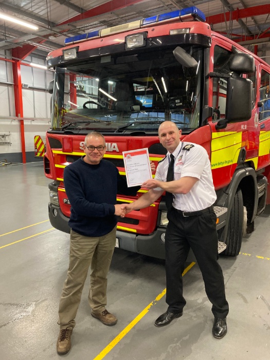 Derbyshire's Deputy Chief Fire Officer, Rob Taylor, presenting Jeremy West with a commendation for his bravery