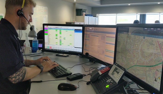 over the shoulder shot of control operator looking at 3 screens