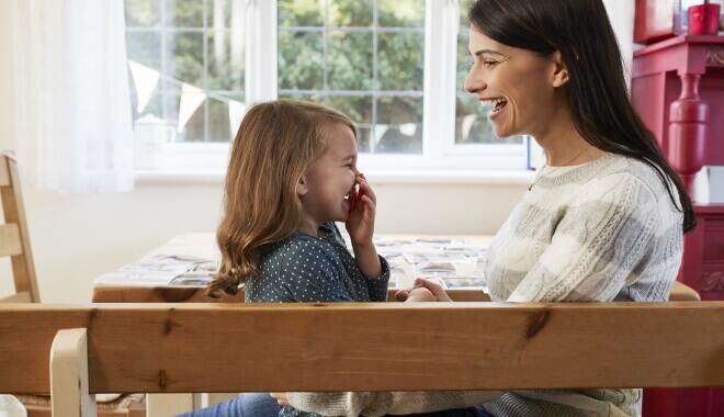 mother and child in family room laughing together