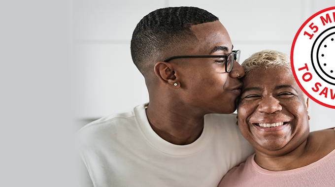 young black man kissing his mother on the head who is smiling happily